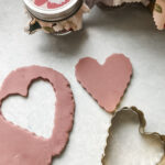 purple homemade playdough rolled out and cut out with a scalloped heart shape