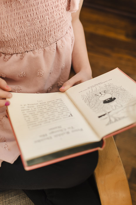 girl in a pink dress reading a book
