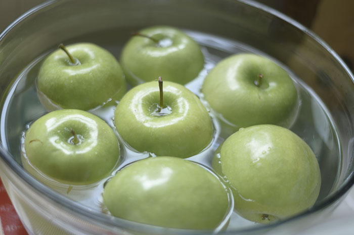 Granny Smith apples in a bowl of water